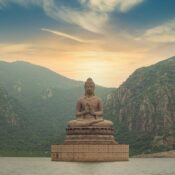 brown buddha statue near green mountain under blue sky during daytime